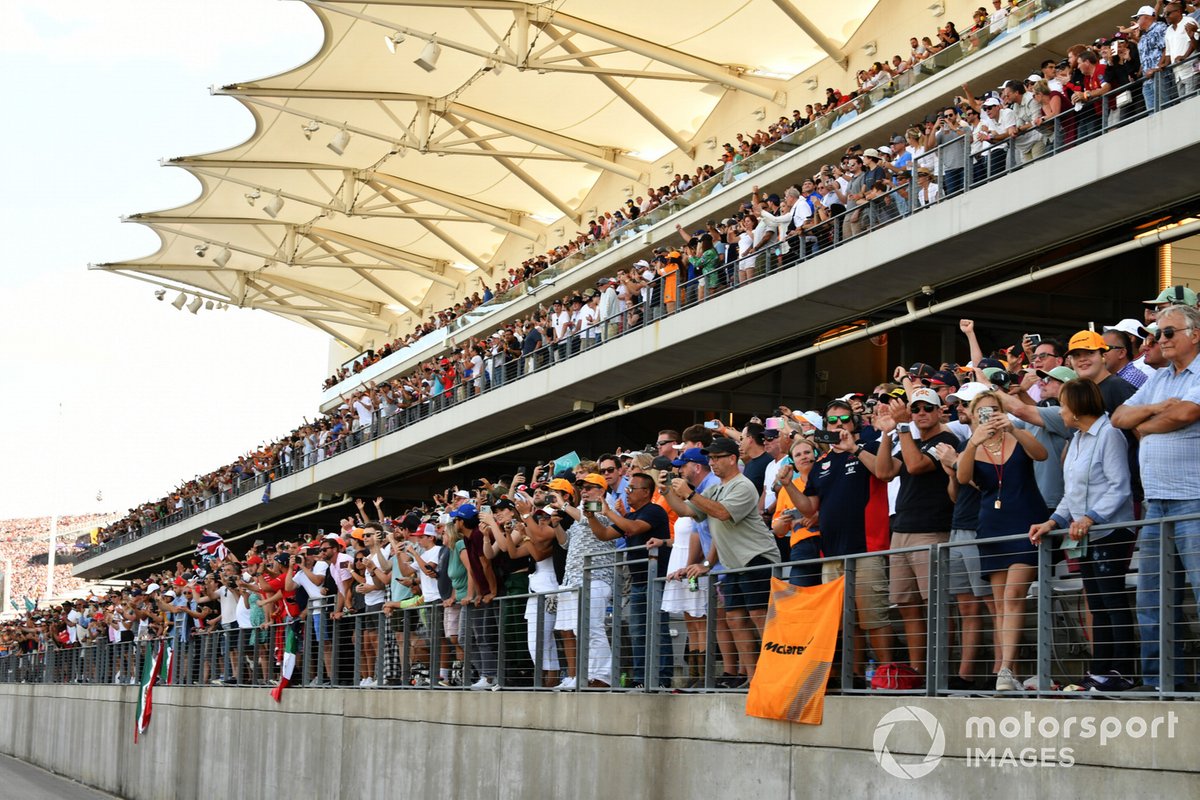 Fans in a grandstand take photos