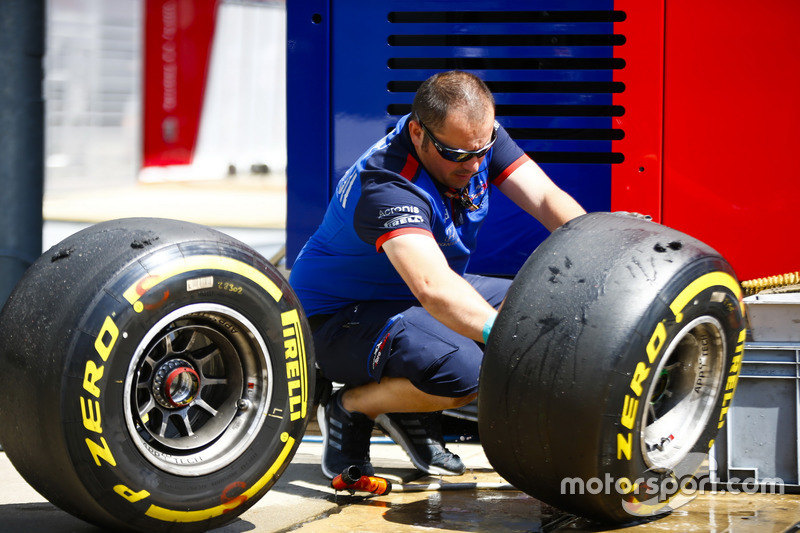 A Toro Rosso engineer washes some tyres