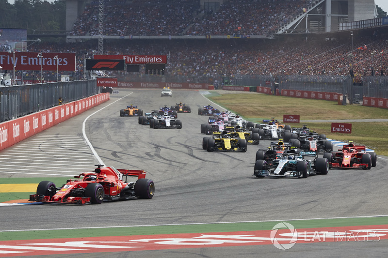 Sebastian Vettel, Ferrari SF71H, leads Valtteri Bottas, Mercedes AMG F1 W09, Kimi Raikkonen, Ferrari SF71H, Max Verstappen, Red Bull Racing RB14, Kevin Magnussen, Haas F1 Team VF-18, Nico Hulkenberg, Renault Sport F1 Team R.S. 18, and the rest of the field at the start