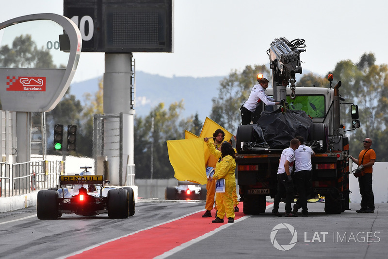 Marshals wave yellow flags in pit lane