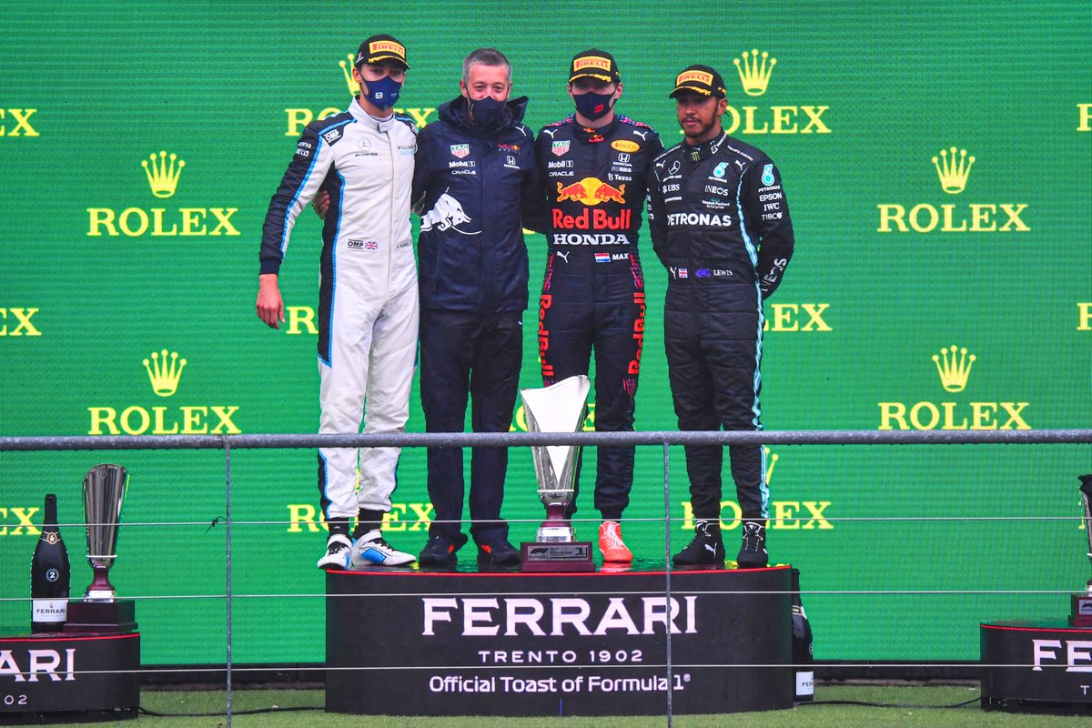 George Russell, Williams, 2nd position, the Red Bull trophy delegate, Max Verstappen, Red Bull Racing, 1st position, and Lewis Hamilton, Mercedes, 3rd position, on the podium