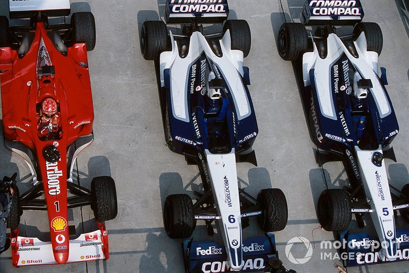 Michael Schumacher parks his Ferrari F2001 next to the Williams FW24 of Ralf Schumacher and Juan Pablo Montoya in parc ferme