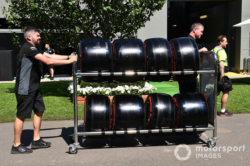 Pirelli personnel wheel tyres through the paddock