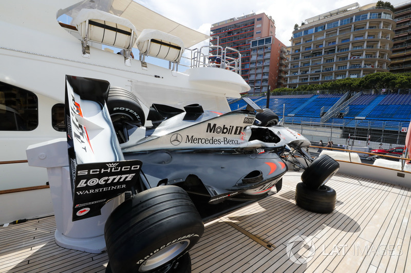 An old Mika Hakkinen McLaren is displayed on the deck of a boat in the harbour