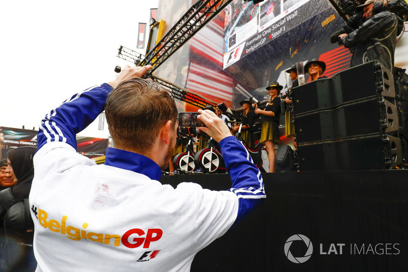 A fan takes a picture of the Grid Girls on stage in the F1 Fanzone