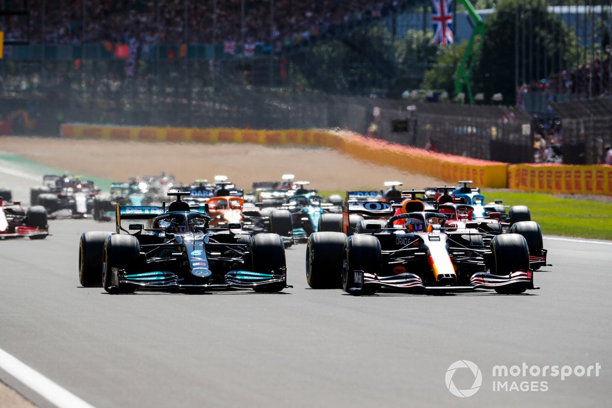 Max Verstappen, Red Bull Racing RB16B berduel dengan Lewis Hamilton, Mercedes W12 selepas start F1 GP Inggris, Minggu (18/7/2021).