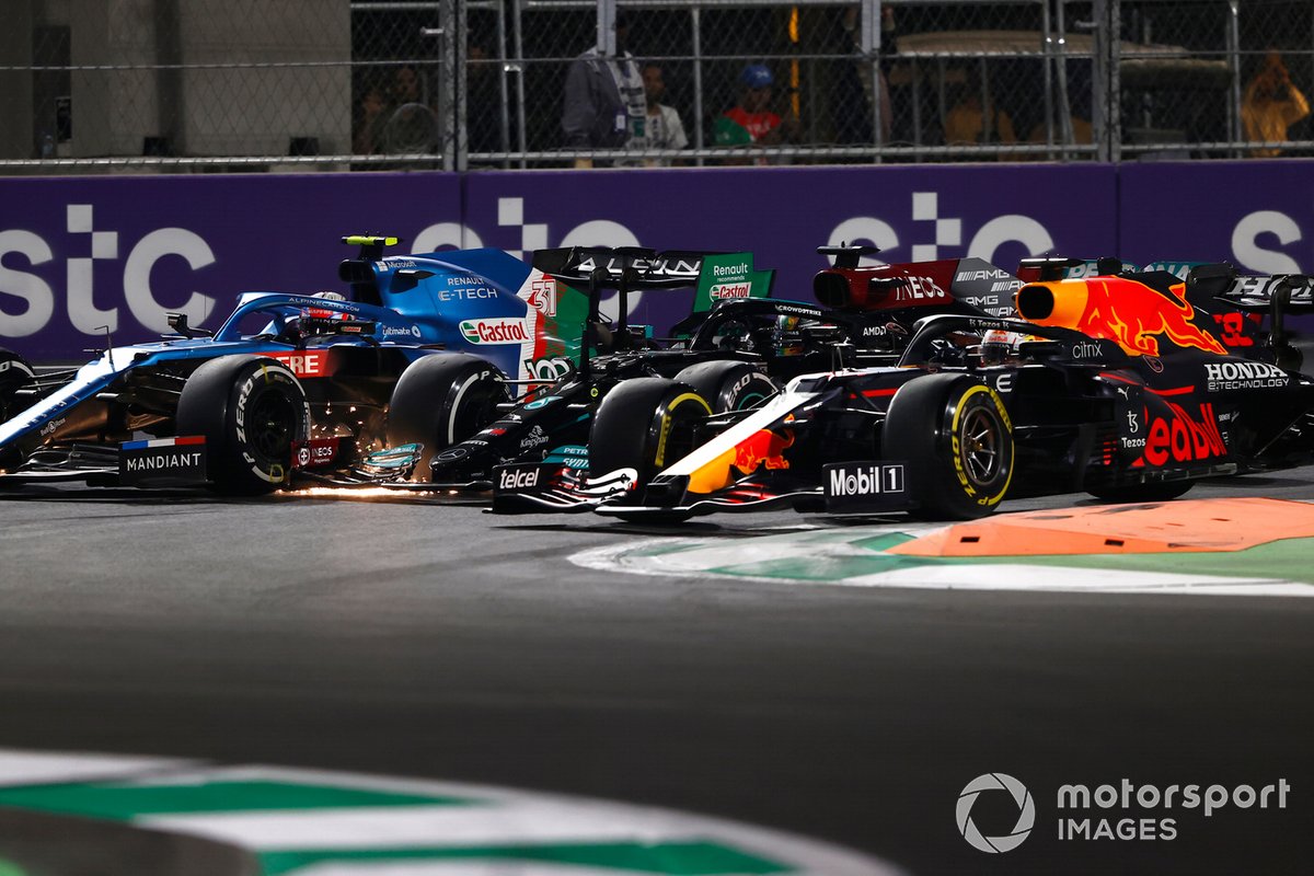 Max Verstappen, Red Bull Racing RB16B, Lewis Hamilton, Mercedes W12, and Esteban Ocon, Alpine A521, battle for the lead at the restart