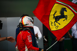 Sebastian Vettel, Ferrari, festeggia la vittoria sventolando una bandiera con il Cavallino Rampante