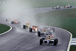 Ayrton Senna kämpft sich durch das Feld in der ersten Runde, während Alain Prost führt