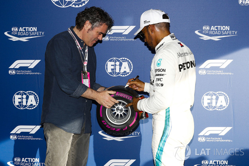 Lewis Hamilton, Mercedes AMG F1, signs a miniature Pirelli tyre after taking pole position