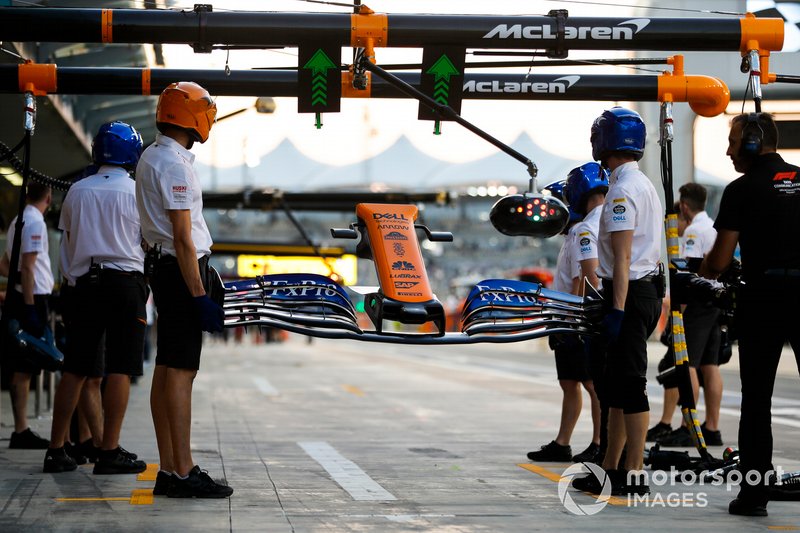 Mechanics holds a nose and front wing, and wait for Carlos Sainz Jr., McLaren MCL34, to make a pit stop.
