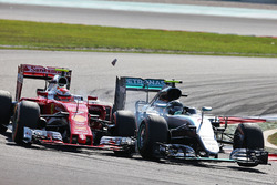 (L naar R): Kimi Raikkonen, Ferrari SF16-H en Nico Rosberg, Mercedes AMG F1 W07 Hybrid raken elkaar