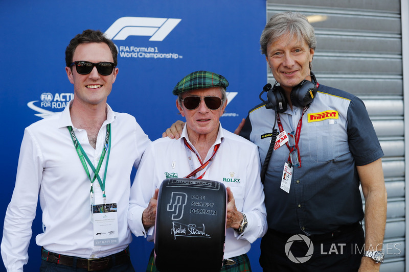 Sir Jackie Stewart tient un pneu avec le message Race Against Dementia