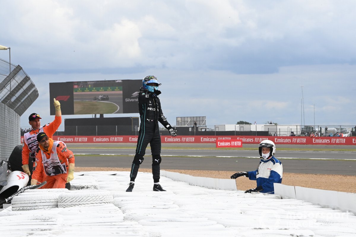 George Russell, Mercedes-AMG, assists marshals in extracting Zhou Guanyu, Alfa Romeo F1 Team, from his car