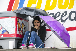 Una aficionada se cubre de la lluvia en las tribunas