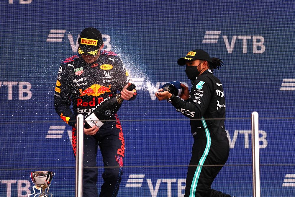 Max Verstappen, Red Bull Racing, 2e plaats, wordt door Lewis Hamilton, Mercedes, 1e plaats, op het podium bespoten met Champagne