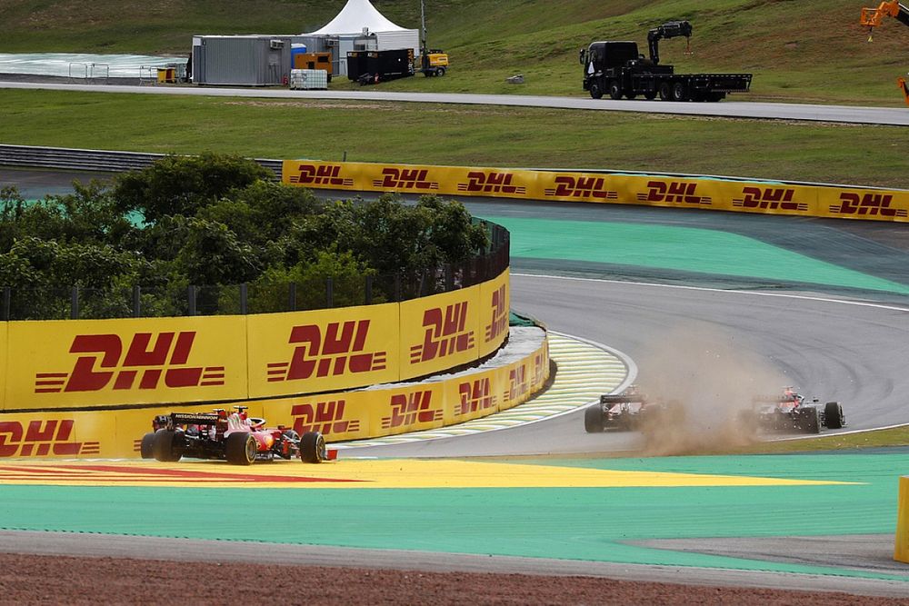 Dust flies as Carlos Sainz Jr., Ferrari SF21, battles with Max Verstappen, Red Bull Racing RB16B