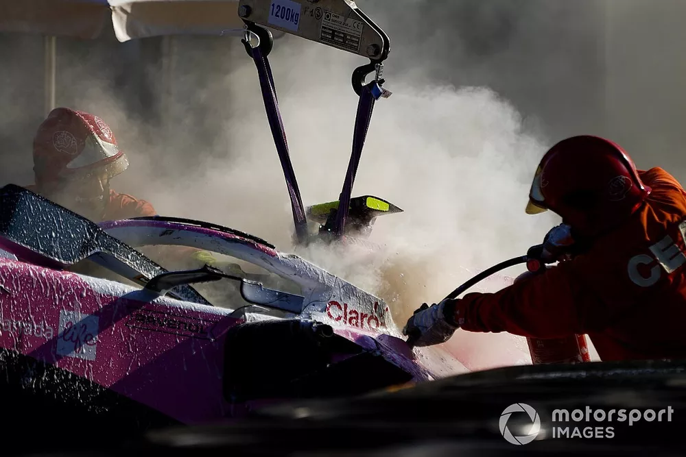 Fire marshals extinguish the car of Lance Stroll, Racing Point RP20