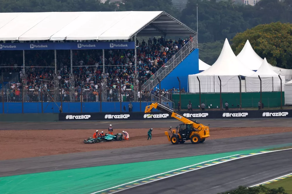 Marshals recover Lance Stroll, Aston Martin AMR24, from the gravel prior to the start