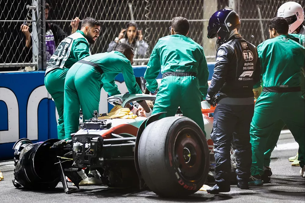 Marshals and medics assist Mick Schumacher, Haas VF-22, after his crash in Q2