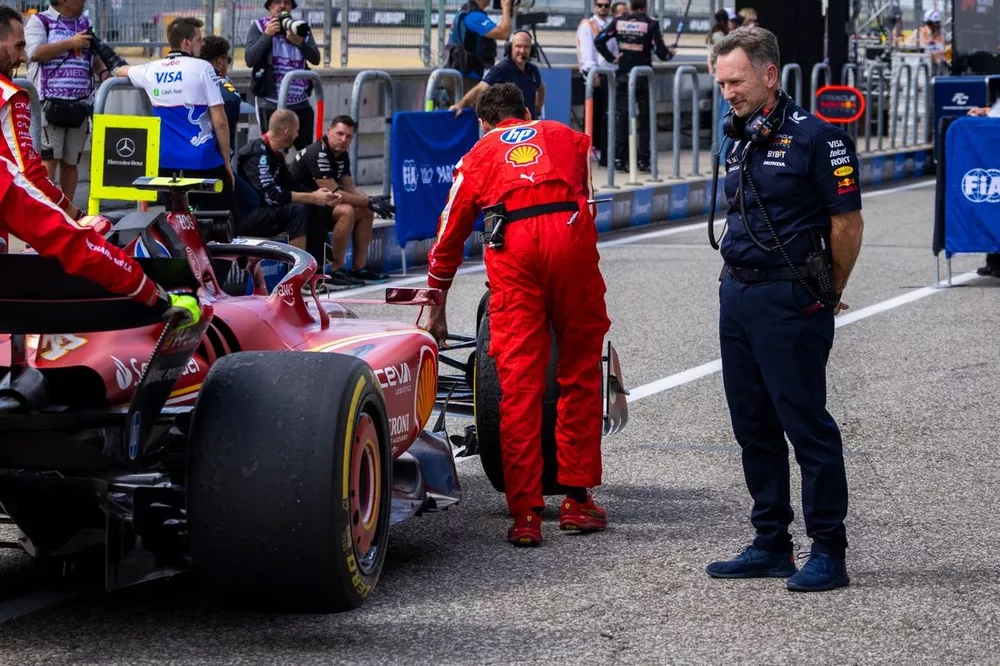 Christian Horner, Team Principal, Red Bull Racing, guarda i meccanici che portano la monoposto di Carlos Sainz, Ferrari SF-24, fuori dal Parc Ferm&eacute; 