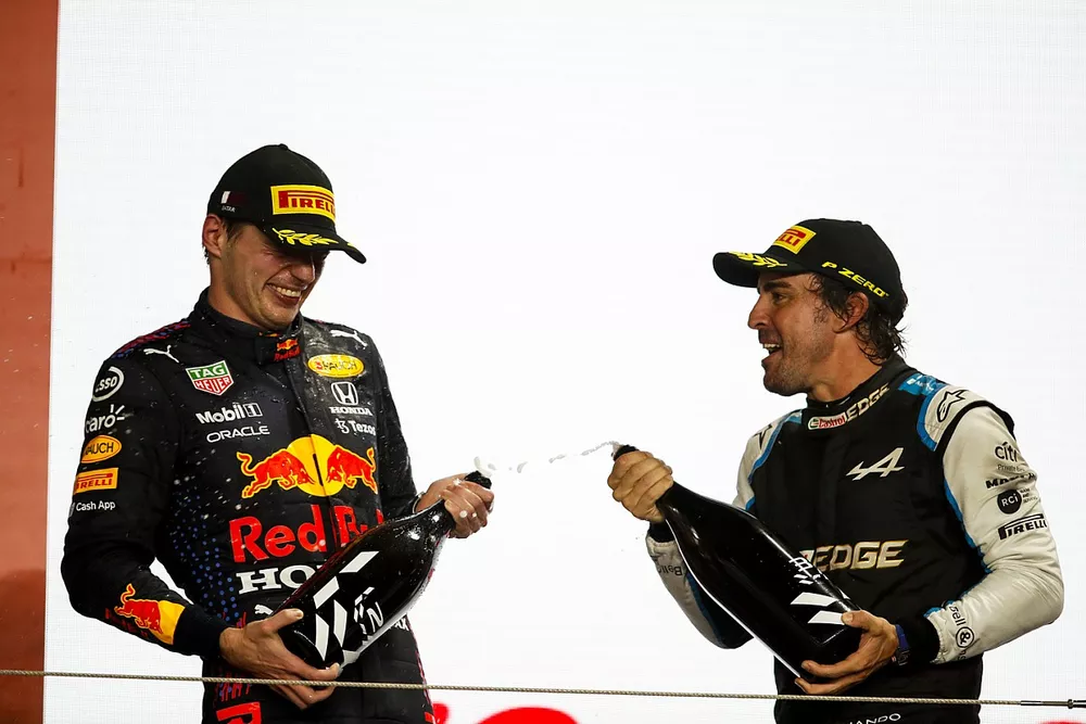 Max Verstappen, Red Bull Racing, 2nd position, and Fernando Alonso, Alpine F1, 3rd position, celebrate on the podium with Rose Water