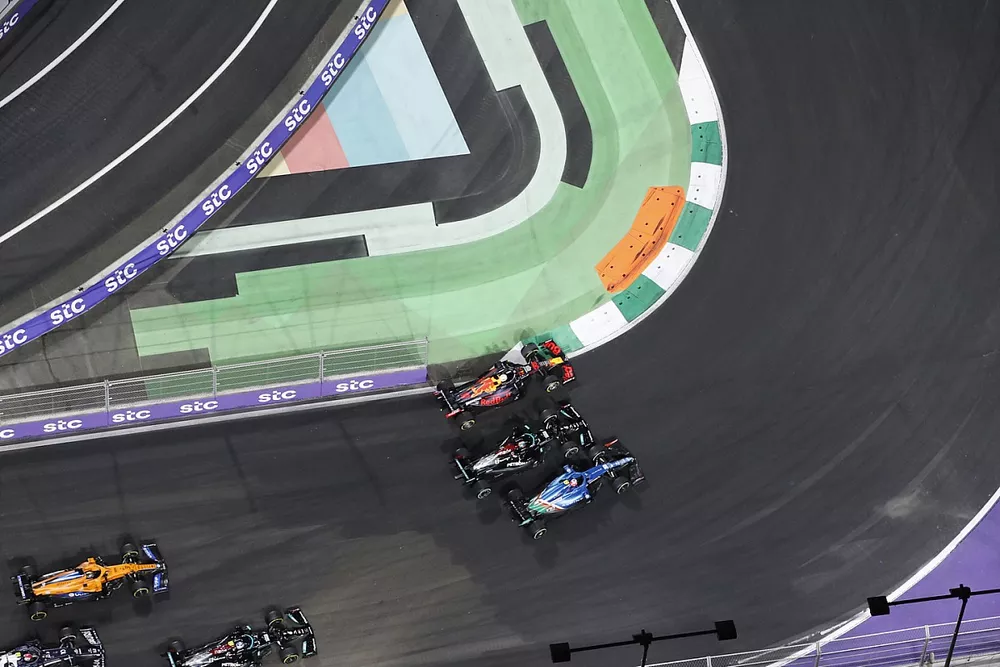 Max Verstappen, Red Bull Racing RB16B, Esteban Ocon, Alpine A521, and Lewis Hamilton, Mercedes W12, battle for the lead