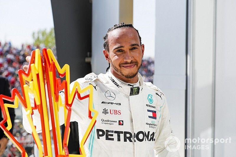 Lewis Hamilton, Mercedes AMG F1 celebrates behind the podium with the trophy