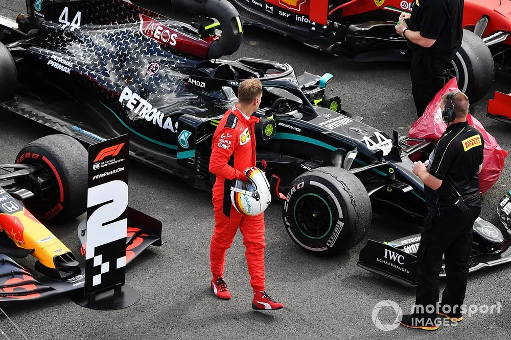 Sebastian Vettel, Ferrari, looks at the punctured tyre of Lewis Hamilton, Mercedes F1 W11, in Parc Ferme