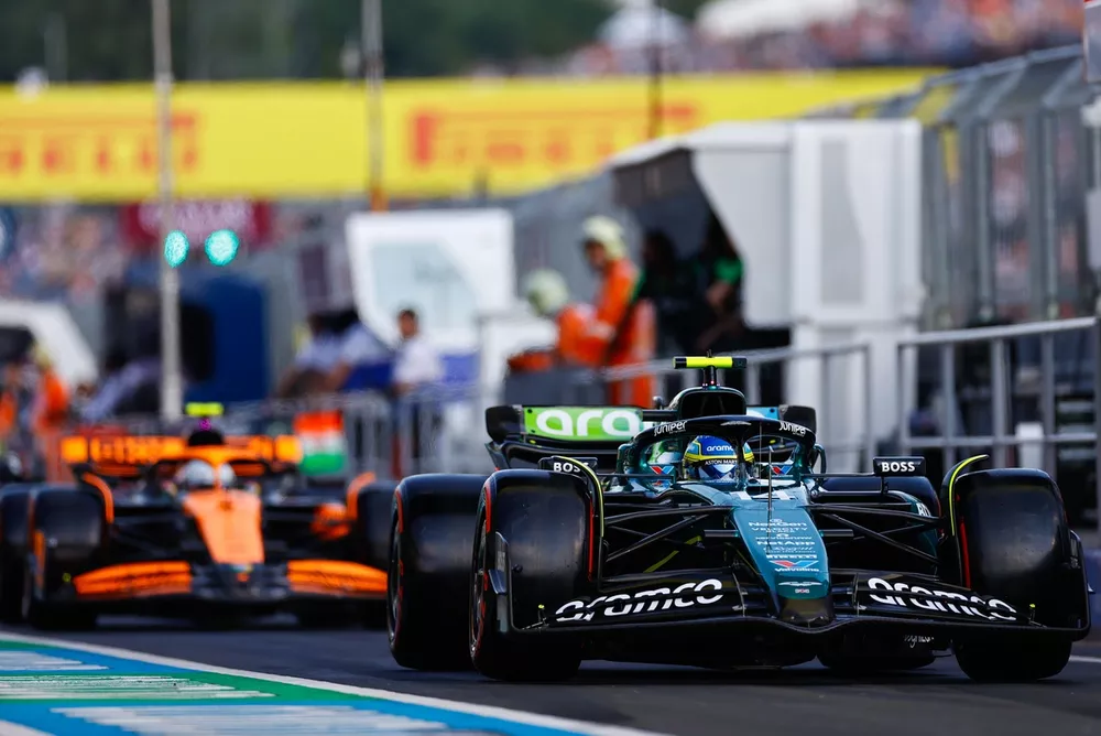 Fernando Alonso, Aston Martin AMR24, leads Lando Norris, McLaren MCL38, in the pit lane