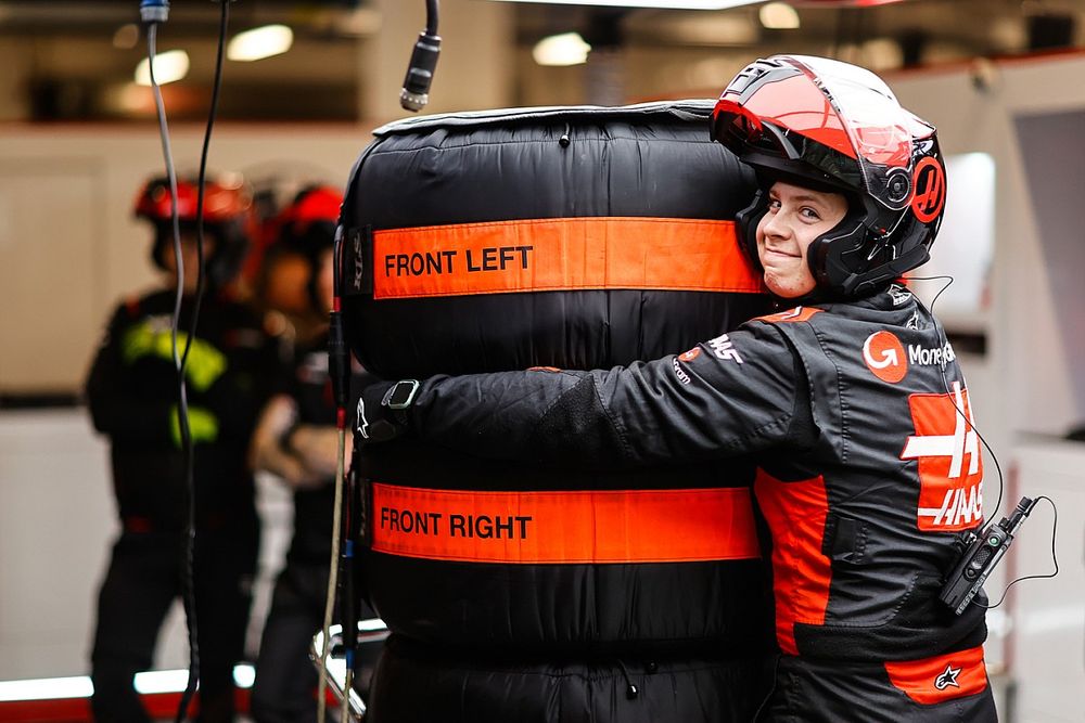 A team member of the Haas F1 Team hugs the tyres