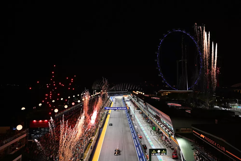 Fireworks light the sky at the end of the race as Oscar Piastri, McLaren MCL38, and Fernando Alonso, Aston Martin AMR24, cross the line