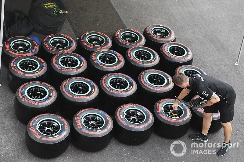 A Mercedes AMG F1 employee checks Pirelli tyres