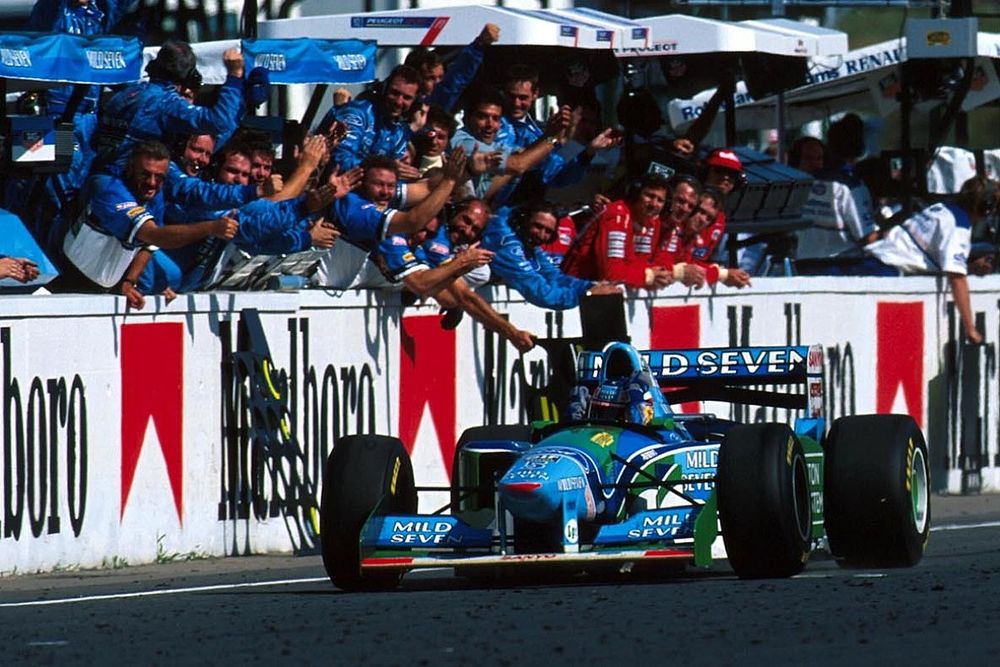 Michael Schumacher, Benetton B194, celebra con el equipo de Benetton mientras cruza la línea de meta