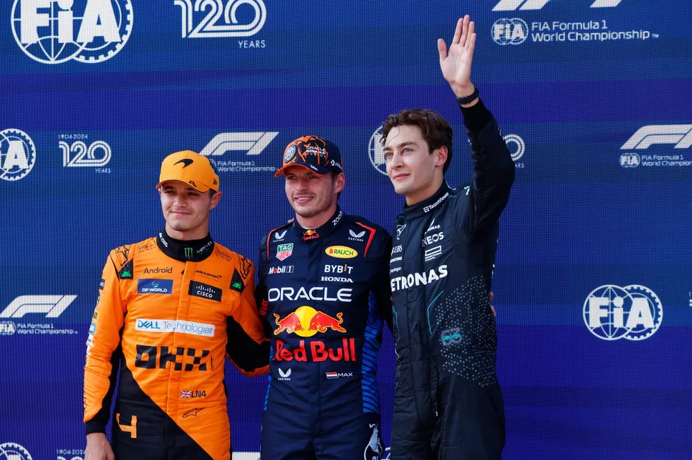 Max Verstappen, Red Bull Racing, celebrates pole position between Lando Norris, McLaren F1 Team and a waving George Russell, Mercedes-AMG F1 Team