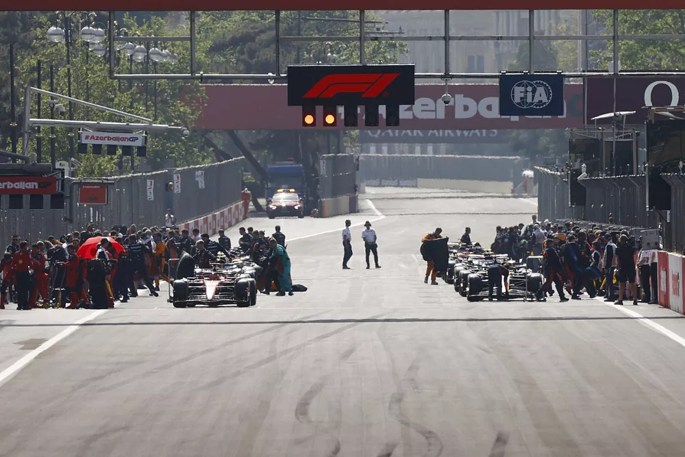 Mechanics clear the grid , Charles Leclerc, Ferrari , Max Verstappen, Red Bull Racing RB19, prepare to lead the field away for the start