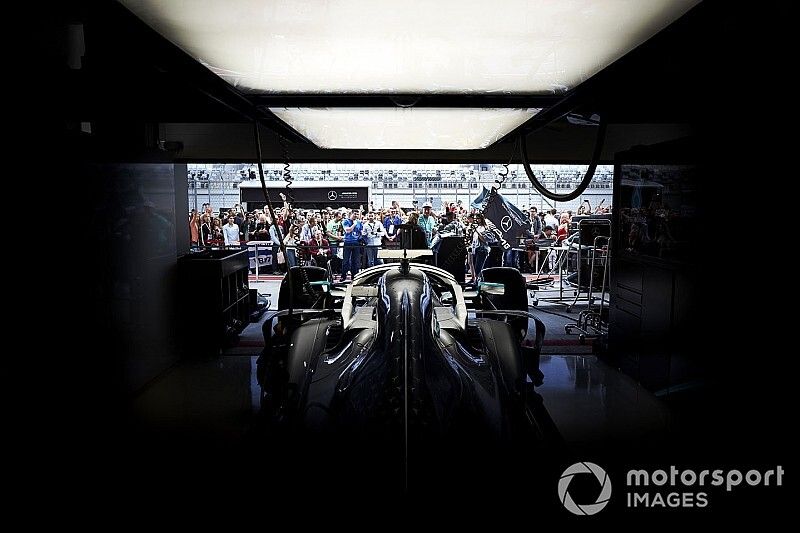 Mercedes AMG F1 W10 detailFans in the pit lane walk outside of the AMG Mercedes garage