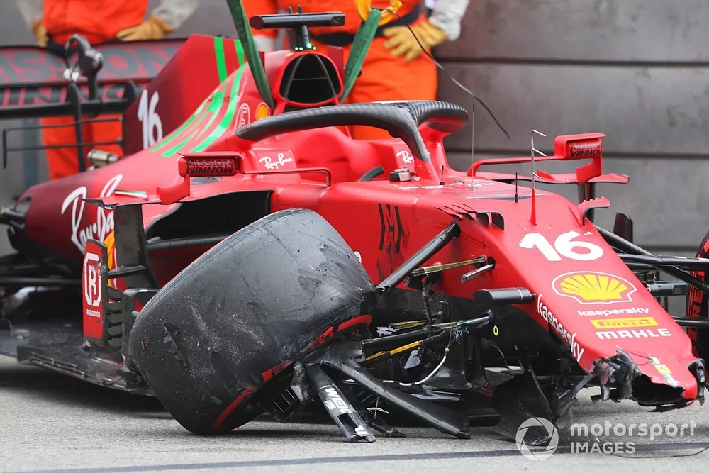 Des commissaires d&eacute;gagent la voiture de Charles Leclerc, Ferrari SF21, du circuit