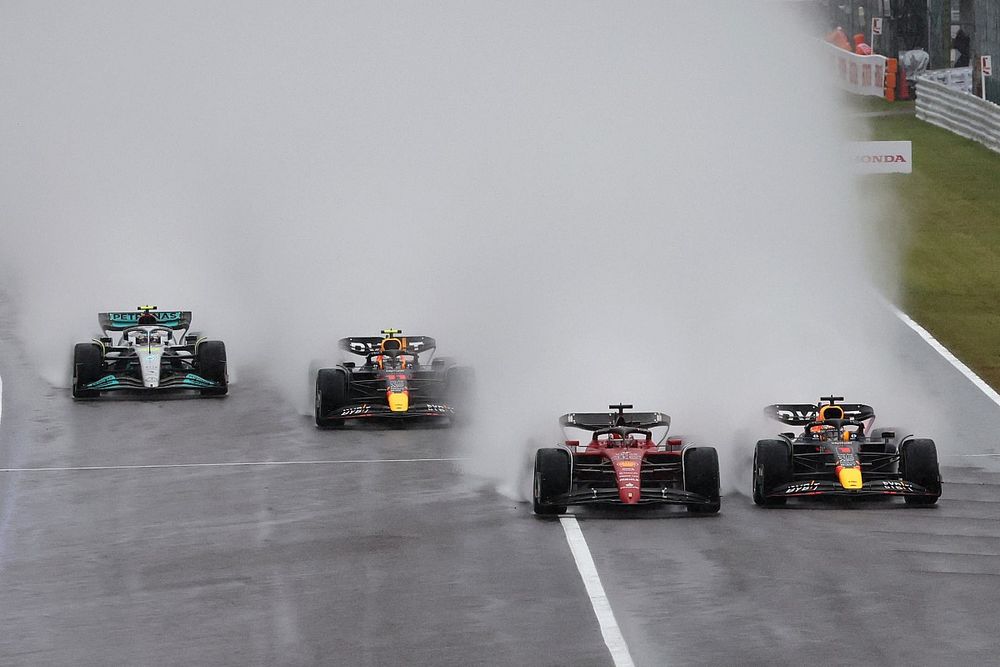Max Verstappen, Red Bull Racing RB18, battles with Charles Leclerc, Ferrari F1-75, ahead of Sergio Perez, Red Bull Racing RB18, Lewis Hamilton, Mercedes W13, the rest of the field at the start