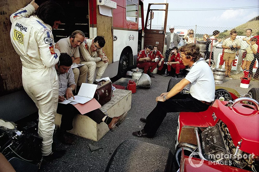 D&eacute;briefing chez Lotus avec le nouveau pilote Emerson Fittipaldi, le directeur sportif Dick Scammell, le fondateur et directeur Colin Chapman, John Miles, et assis sur la Lotus, Jochen Rindt