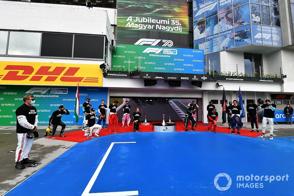 Los otros pilotos se re&uacute;nen alrededor de los trofeos antes del comienzo en apoyo de la campa&ntilde;a para el fin del racismo