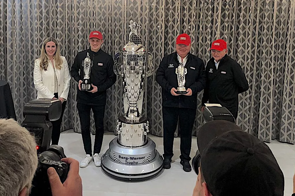 Marcus Ericsson and Chip Ganassi receive Baby Borgs for 2022 Indy 500 win, accompanied by Michelle Collins of BorgWarner Inc. and Mike Hull, managing director of Chip Ganassi Racing
