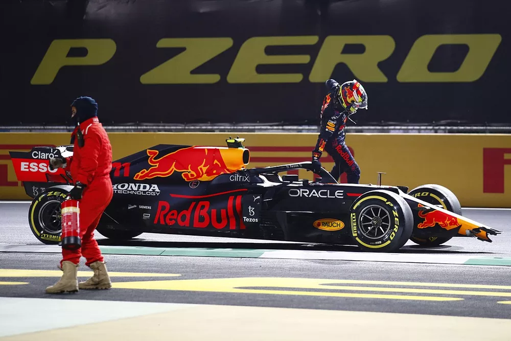 Sergio Perez, Red Bull Racing RB16B, jumps out of his car after a crash at the restart