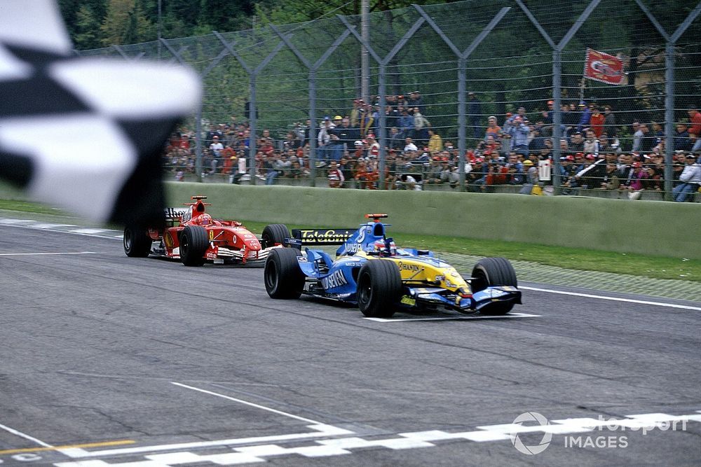 El ganador de la carrera Fernando Alonso, Renault R25, toma la bandera a cuadros, seguido por Michael Schumacher, Ferrari F2005