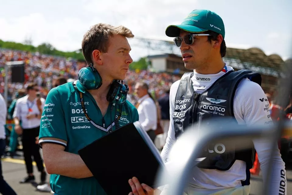 Lance Stroll, Aston Martin F1 Team, habla con un ingeniero en la parrilla de salida