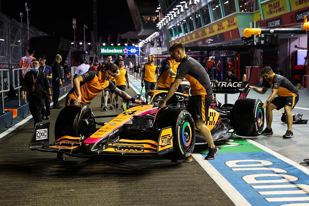 Los mec&aacute;nicos de McLaren empujan el McLaren MCL36 de Lando Norris en el pit lane