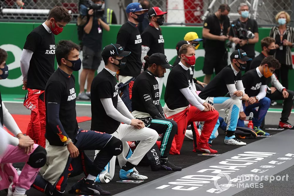 The drivers take a knee and stand in support of the End Racism Campaign before the race