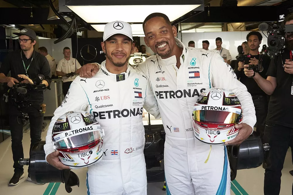 Lewis Hamilton, Mercedes AMG F1 and Will Smith pose in the Mercedes garage