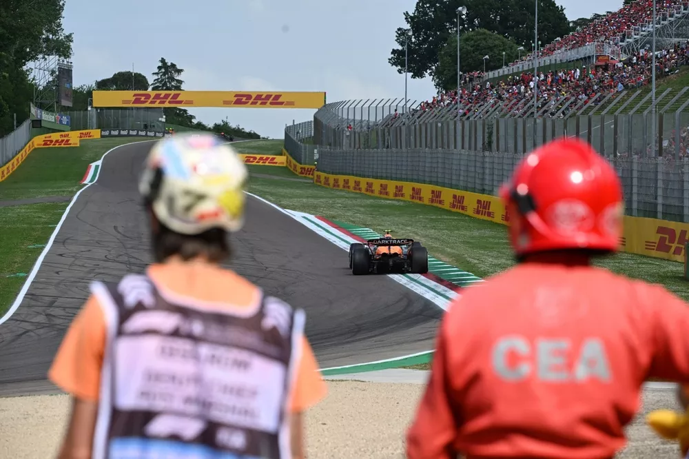 Los comisarios observan el paso de Lando Norris, McLaren MCL38
