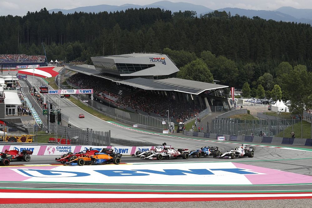 Daniel Ricciardo, McLaren MCL35M, Charles Leclerc, Ferrari SF21, Kimi Raikkonen, Alfa Romeo Racing C41, and the remainder of the field on the opening lap